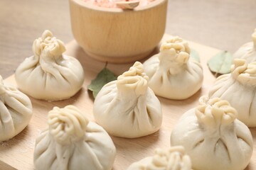 Uncooked khinkalis (dumplings) and spices on table, closeup