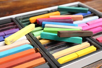 Set of colorful chalk pastels on wooden table, closeup