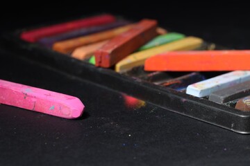 Colorful chalk pastels on black background, closeup