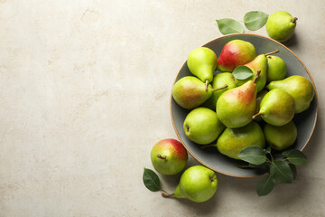 Fresh ripe pears and green leaves on light grey table, flat lay. Space for text