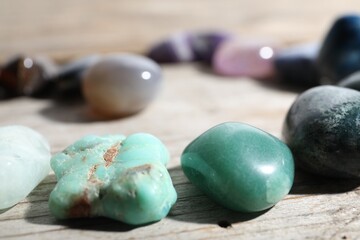 Many different healing stones on wooden table, closeup