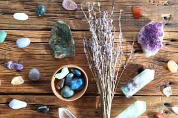 Different healing stones and lavender on wooden table, flat lay