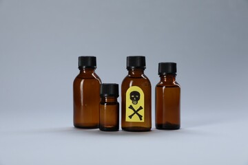 Bottles of poisons with warning sign on light grey background