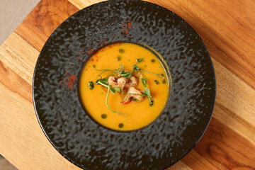 Delicious and Creamy Pumpkin Soup with Fresh Herbs and a Colorful Garnish for Taste