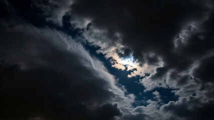 Obraz premium Dramatic skyscape with celestial light filtering through dense ominous clouds formations unveiling a breathtaking contrast and visual spectacle