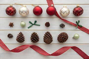 Festive Christmas ornaments and pine cones arranged with a red polka dot ribbon for holiday cheer PNG