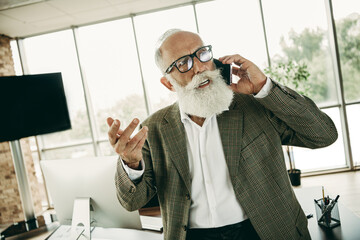 Modern Senior Professional Speaking on Smartphone in Stylish Office Setting with Beard and Formal...