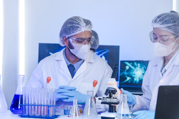 A team of scientists in a high-tech lab collaborates on genetic and medical research. They use...