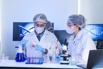 Fototapeta premium A team of scientists in a high-tech lab collaborates on genetic and medical research. They use microscopes and test tubes to analyze samples for a new discovery.