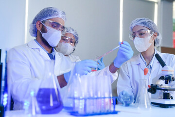 A team of scientists in a high-tech lab collaborates on genetic and medical research. They use...