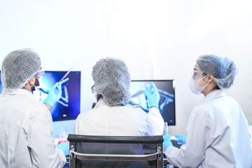 A diverse team of scientists collaborates in a genetics lab. A male researcher explains a procedure...
