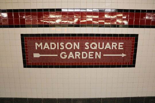 New York, NY, USA - August 26, 2025: large MADISON SQUARE GARDEN sign with arrow and tiled wall inside the manhattan subway
