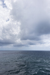 Fototapeta premium Vertical image of Western Caribbean Sea ocean horizon and dramatic overcast cloudscape.