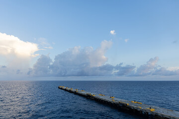 Photo of cruise ship port dock extended on calm sea horizon peaceful cloudscape 