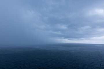 Image of dramatic deep blue ocean horizon on stormy cloudy day rain moving in. Photo taken from...