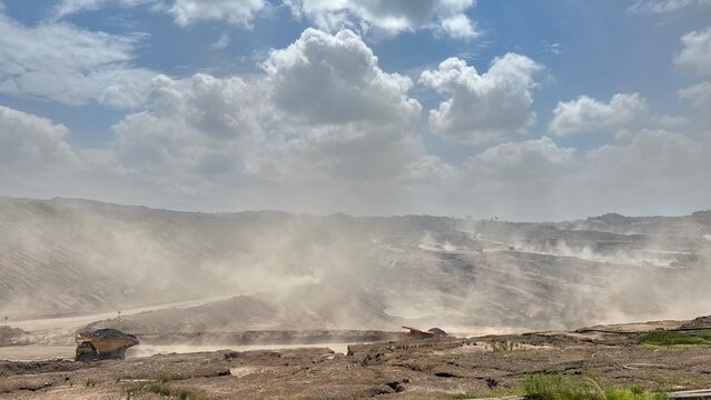 Mining landscape reveals industrial impact, showcasing environmental challenge and natural resource extraction under cloudy skies today