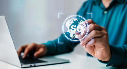 Businessman touching a glowing iso 9001 certification logo with a globe icon on a digital screen, representing quality management and international standards in business operations