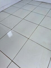 Clean white tile floor pattern offering a modern minimalist backdrop for diverse commercial and...