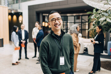 Portrait of happy male business professional wearing eyeglasses at congress center
