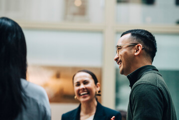 Low angle view of smiling male business expert talking with colleagues at convention center