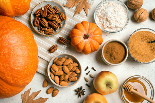 Autumn fall baking background with pumpkins, apples and ingredients