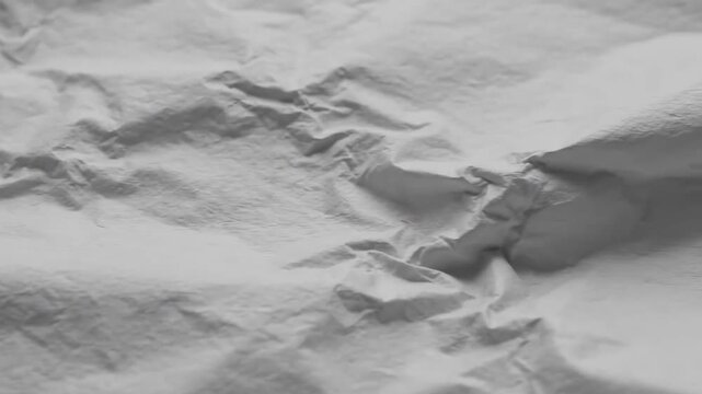 Crumpled Paper Texture - Close-up shot of a heavily creased and folded sheet of white paper, showcasing a textured surface with deep wrinkles and folds.