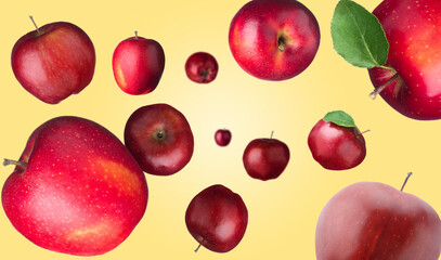 Fresh red apples swirling in air against pale orange background
