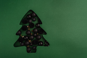 Modern black baubles fill a green Christmas tree-shaped cutout, creating a bold, minimalist holiday design with a dark and elegant twist. Ideal for festive greeting cards, holiday banners