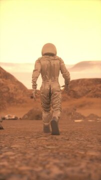 Astronaut Walking Alone on Mars in Orange Dusty Landscape