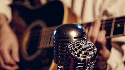 Close-Up Shot of Vintage Style Microphone with Musician Performing on Acoustic Guitar During Nighttime Concert - Powered by Adobe