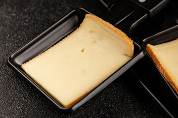 Raclette cheese portion slicing natural product tasty snack fresh delicious gourmet food background on the table rustic top view copy space