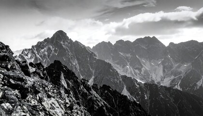 Obraz premium Dramatic Black and White Mountain Peaks Under a Cloudy Sky.