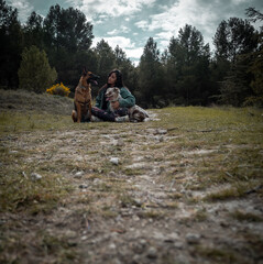 Young girl sitting with her two dogs in the mountain