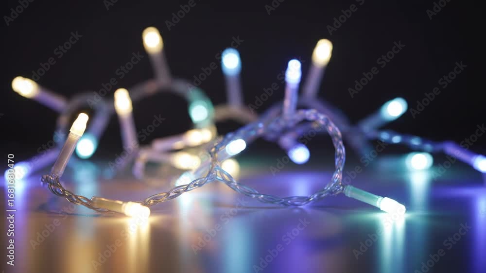 Aufkleber colorful led string lights on dark background - a string of colorful led lights is gently arranged o