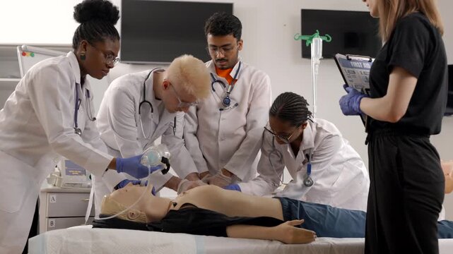 Group of people learning how to make first aid heart compressions with dummies during the training