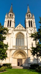Obraz premium Facade of a light beige stone church with tall spires