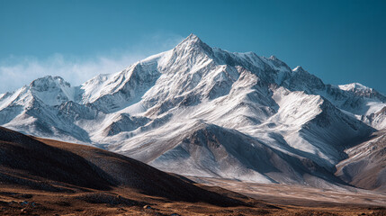 Fototapeta premium Snowy mountain peaks under clear blue sky in a remote wilderness area