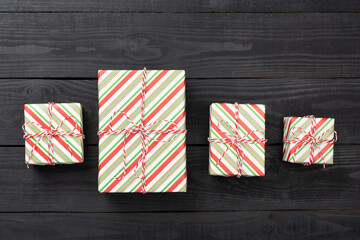 Obraz premium Striped Christmas gift boxes on wooden background, top view