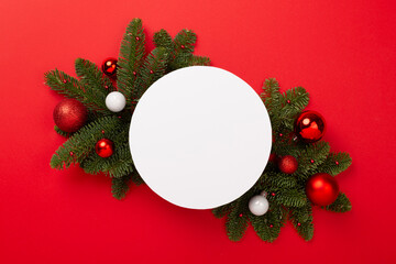 Festive Christmas tree branches with mock up black on color background, top view
