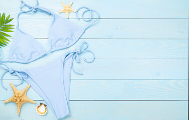 Blue bikini on wooden background, top view