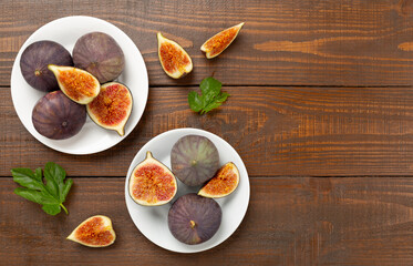 Fresh tasty fig fruits on wooden background, top view