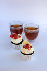 Chocolate cupcakes with cream cheese frosting with festive decorations and tea. Dessert for Valentine's Day or birthday. A wonderful festive treat for a wedding or children's party.