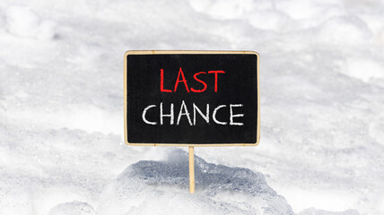 Last chance symbol. Concept word Last chance on beautiful black blackboard. Beautiful white snow...