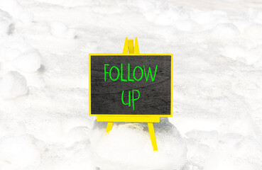 Follow up symbol. Concept word Follow up on beautiful black blackboard. Beautiful white snow...