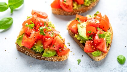 Three triangular avocado toast slices topped with diced tomatoes and basil