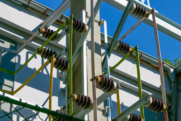 Close-up view of high voltage electrical insulators and power distribution equipment outdoors