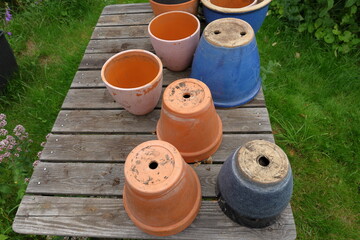 Many flowerpots at a wooden table. Ready for gardening work. Outside photo during the summer.