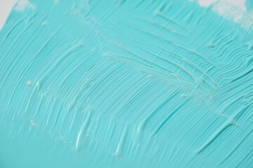 Close up of a vibrant turquoise paint brush stroke texture on a white surface art concept
