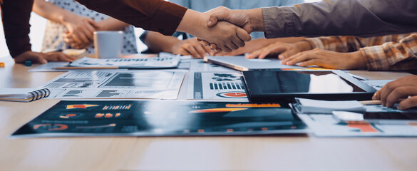 A powerful business handshake symbolizes agreement and collaboration among colleagues in a modern office setting, highlighting teamwork, strategy, and shared goals. SACTR