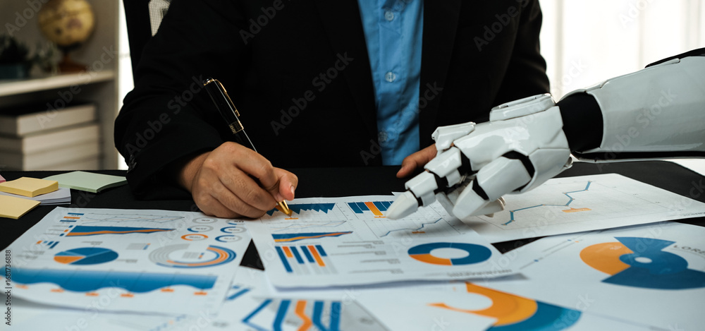 Poster a business professional collaborates with a robot assistant while analyzing detailed charts and grap